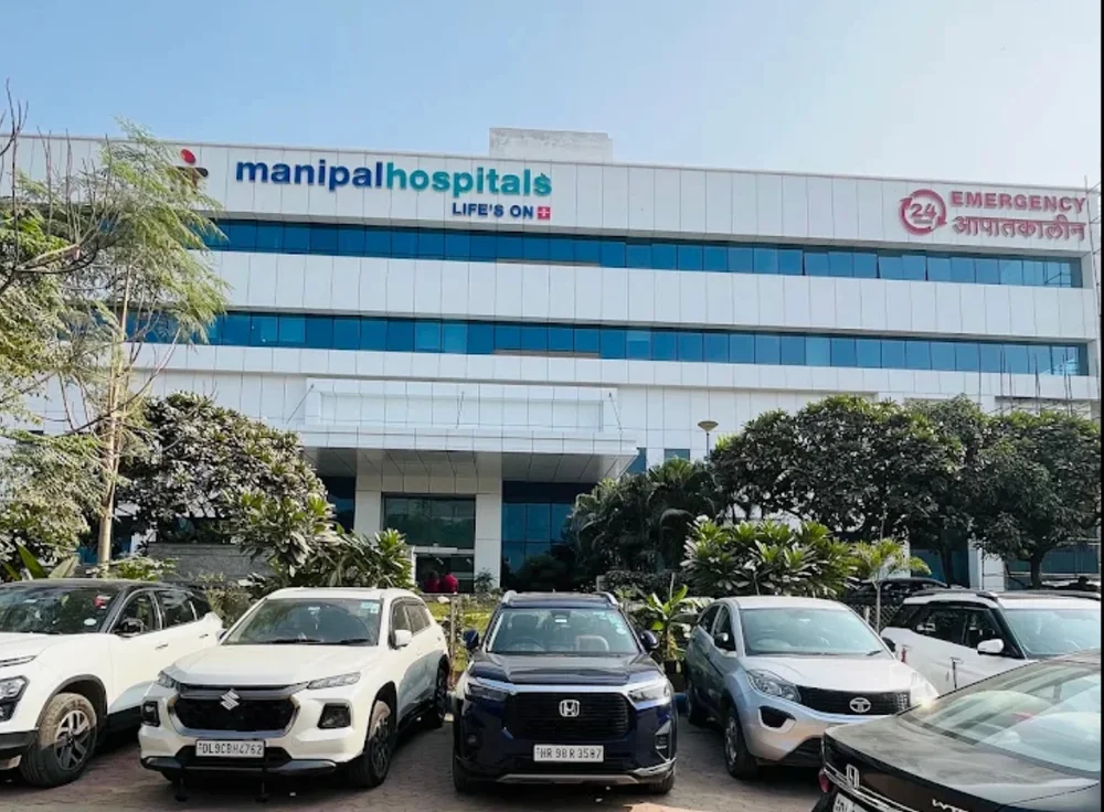 Exterior of Manipal Hospitals Gurugram with the hospital entrance and parking area